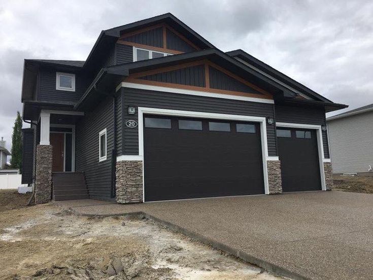 a large house with two garages in the front and one on the other side