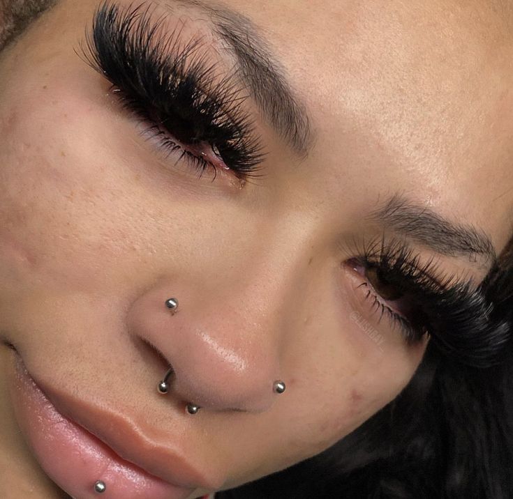 a woman with piercings on her nose looking at the camera