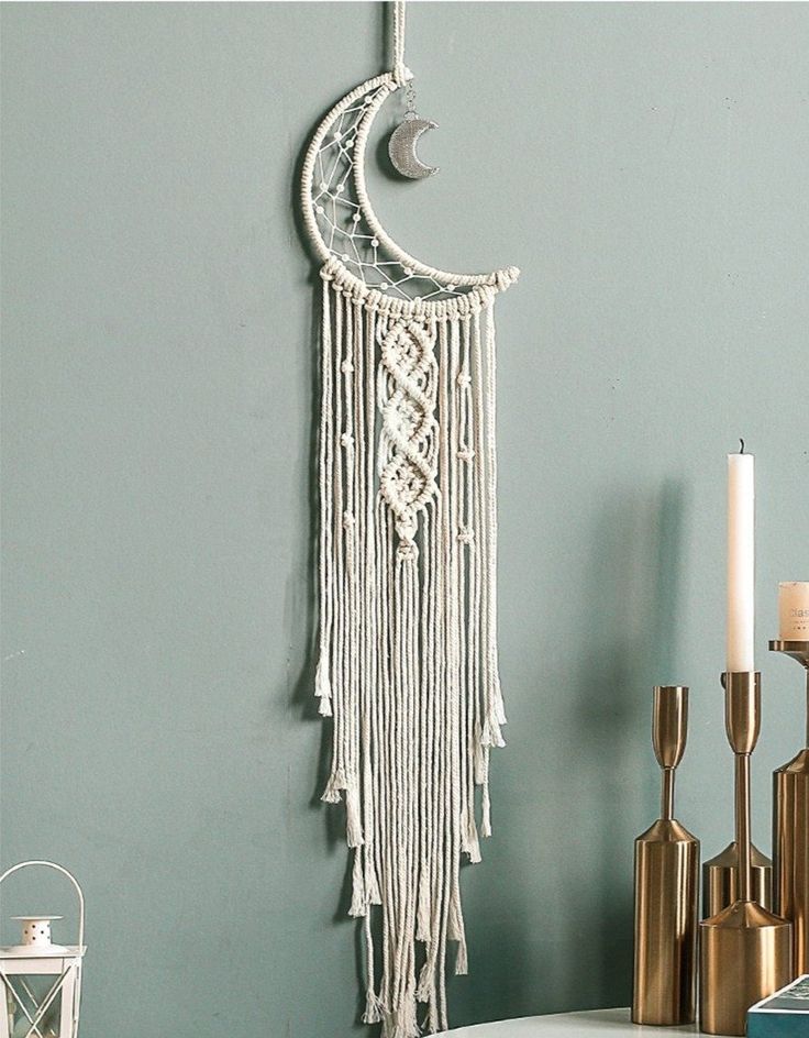 a crescent hanging on the wall next to candles and other items in front of it