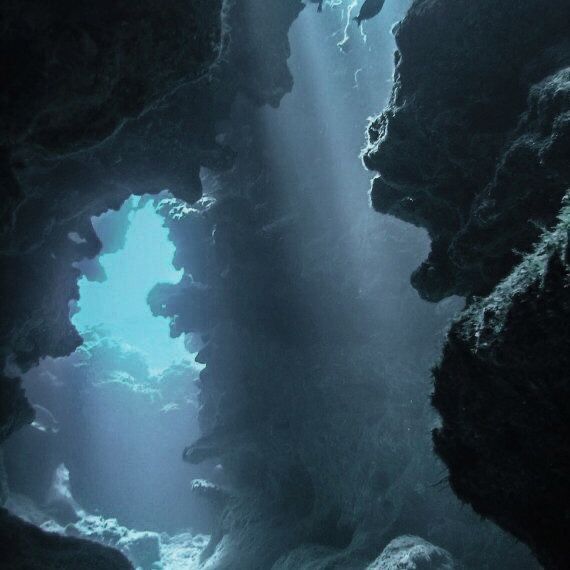 an underwater cave with sunlight streaming through the water