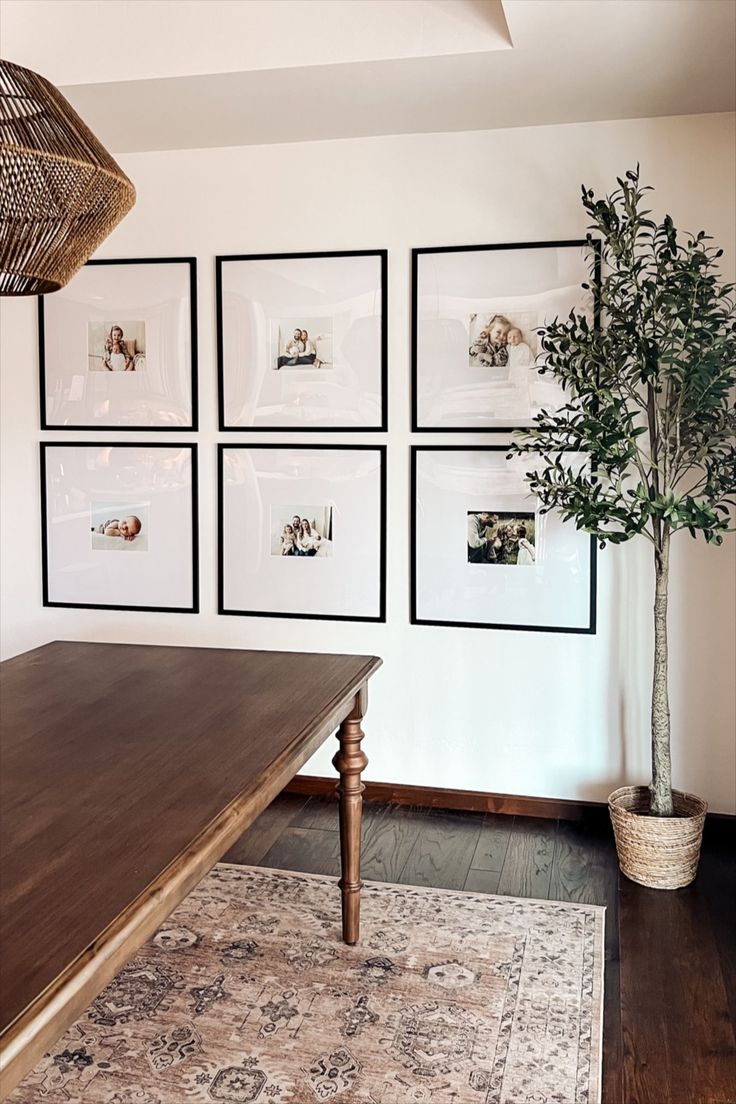 a living room with pictures on the wall and a rug in front of a table