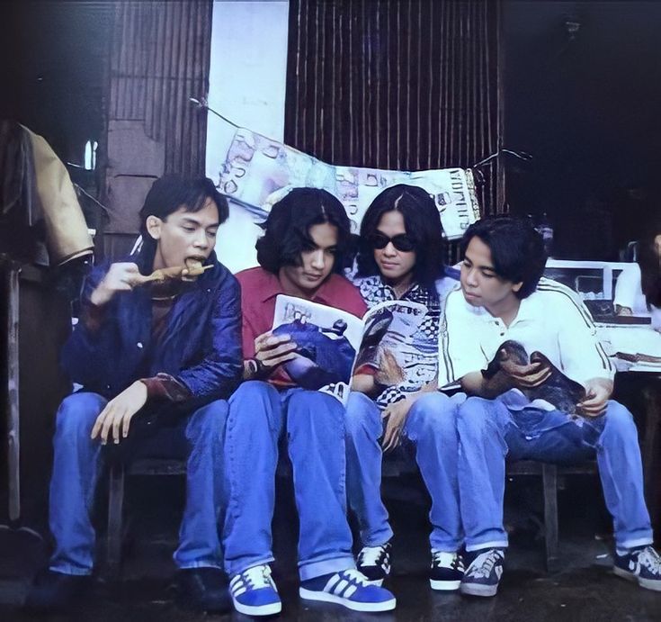 three people sitting on a couch looking at their cell phones