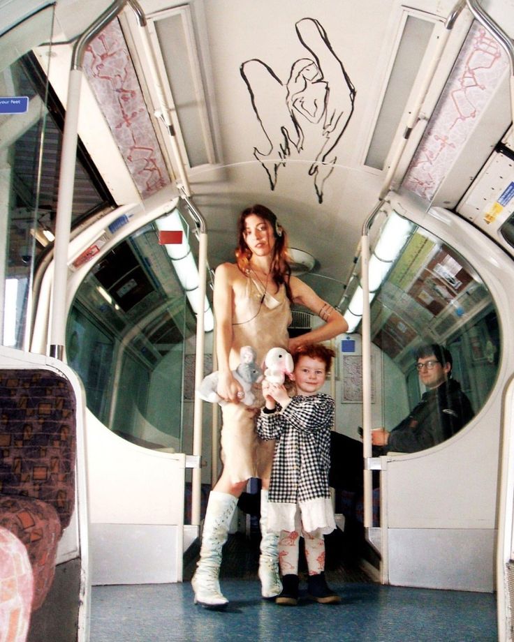 a woman standing next to a child on a train