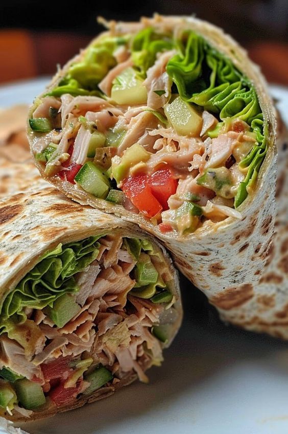 a wrap is cut in half on a plate