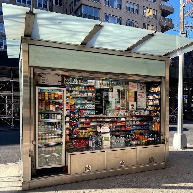 a food stand on the side of a city street with lots of items in it