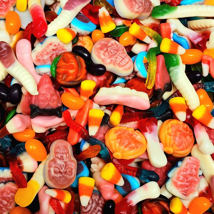 many different colored candy candies are piled on top of each other