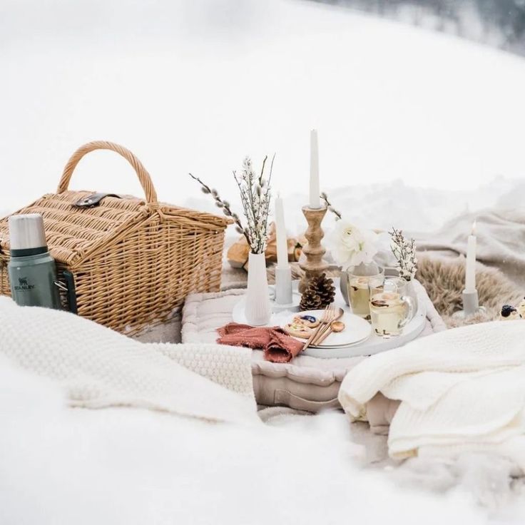 an outdoor picnic with food and drinks in the snow