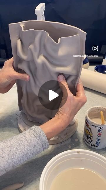 someone is making a vase out of clay