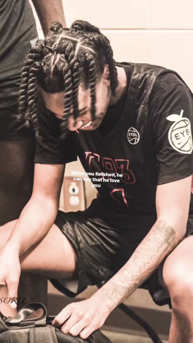 a man with dreadlocks tying his shoes