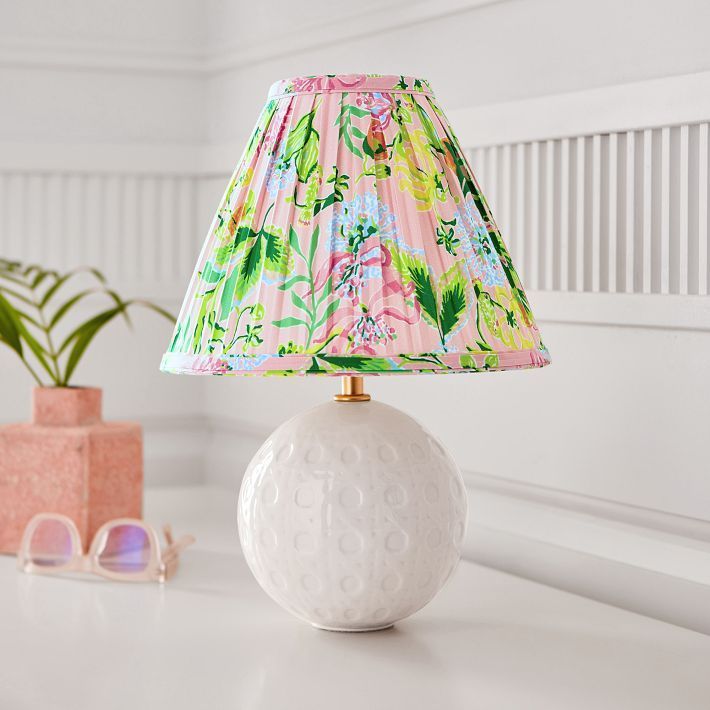 a lamp that is sitting on top of a table next to a potted plant