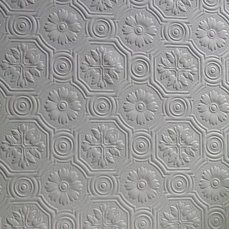 a close up view of a white ceiling tile with circles and flowers on the surface