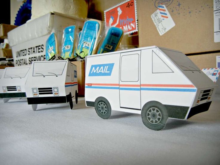 two mail trucks are sitting next to each other in front of cardboard boxes and packages