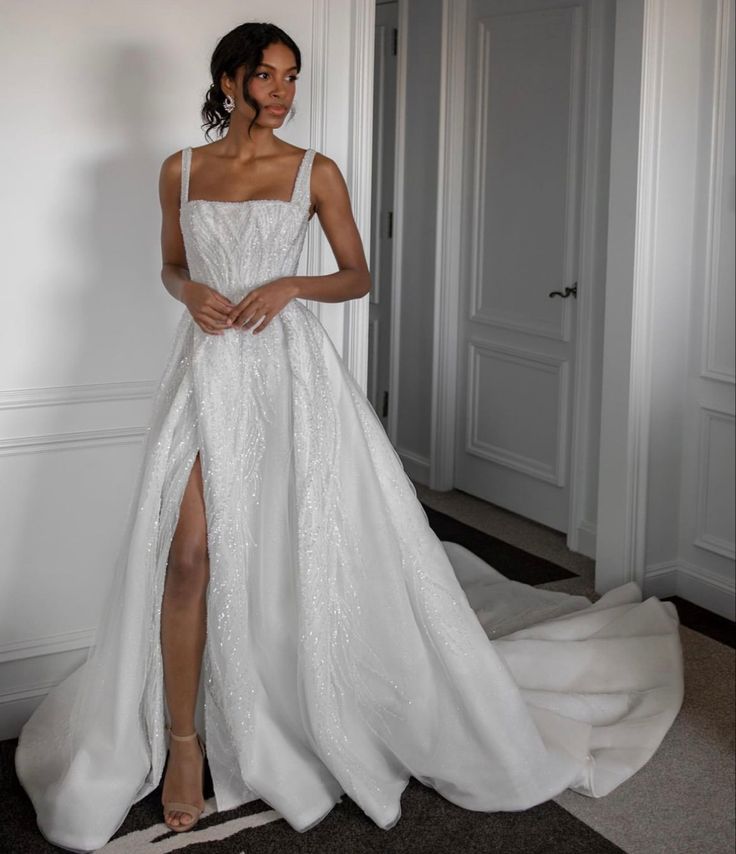 a woman in a white wedding dress posing for the camera