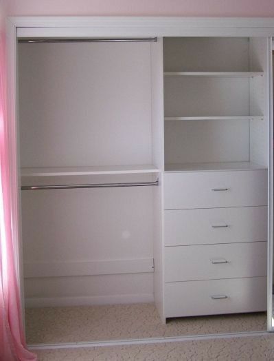 an empty white closet with pink curtains