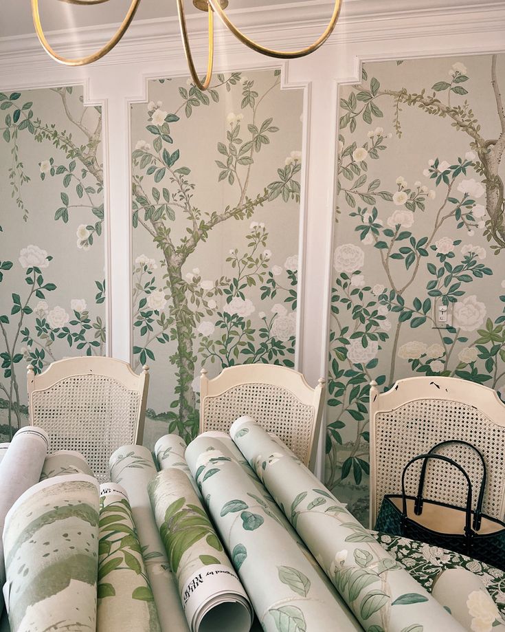 a room with wallpaper and chairs in front of the chandelier that is hanging from the ceiling