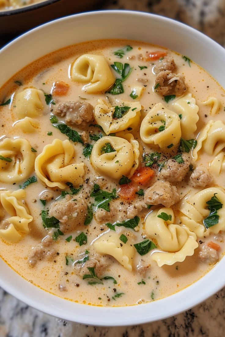 a white bowl filled with pasta and meat soup