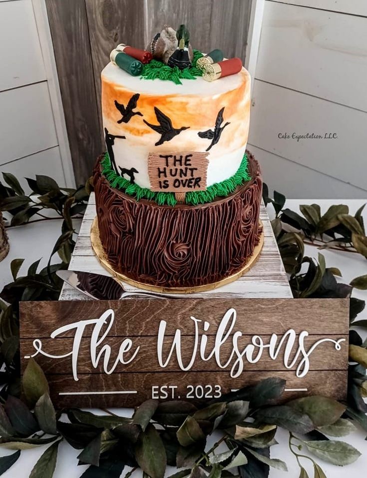 a cake on top of a wooden sign with leaves around it