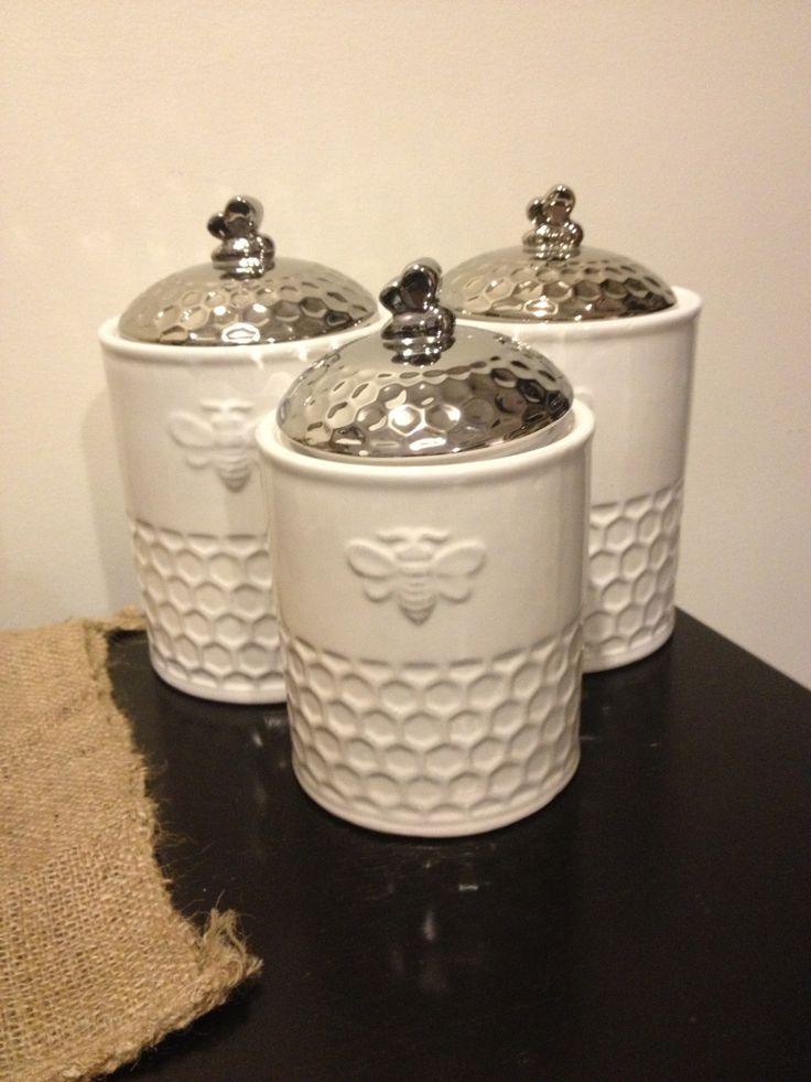 three white canisters sitting on top of a table