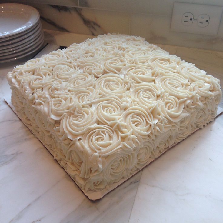 a cake with white frosting sitting on top of a counter