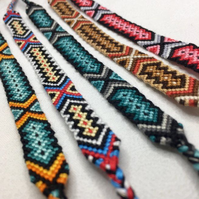 four bracelets with different colors and designs on them, all lined up in the same row