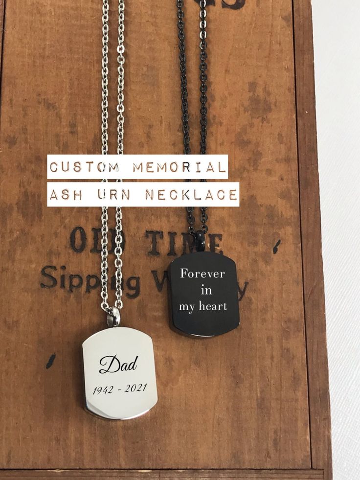 two necklaces on display in a wooden box with words written on them and an inscription that reads, custom memorial ash urn necklace forever in my heart