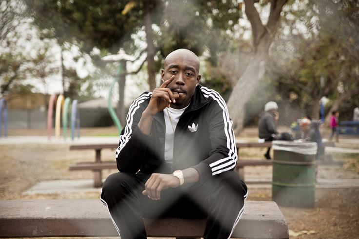 a man sitting on top of a wooden bench