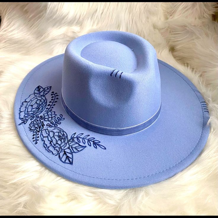 This Blue Western/ Boho Hat Features Florals On The Brim And A Feather Tucked To The Side Of The Blue Velvet Ribbon Hat Band. S/M Polyester Bohemian Blue Felt Hat With Short Brim, Blue Bohemian Felt Hat With Short Brim, Bohemian Blue Short Brim Felt Hat, Blue Wide Brim Bohemian Felt Hat, Blue Bohemian Wide Brim Felt Hat, Bohemian Blue Wide Brim Felt Hat, Blue Wide Brim Hat For Festival, Trendy Blue Hats For Festival, Trendy Blue Hat For Festival