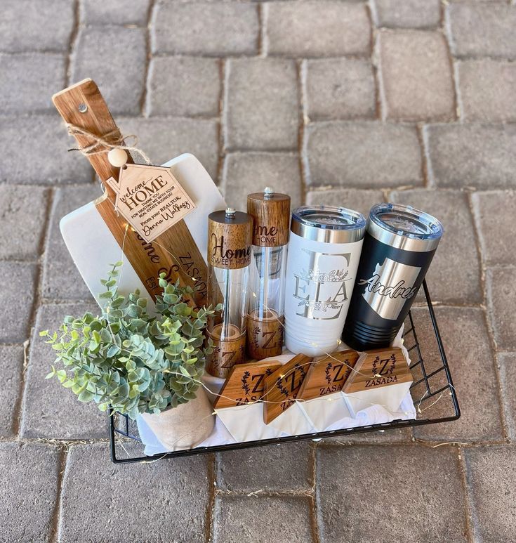 a basket filled with coffee cups sitting on top of a brick floor next to a potted plant