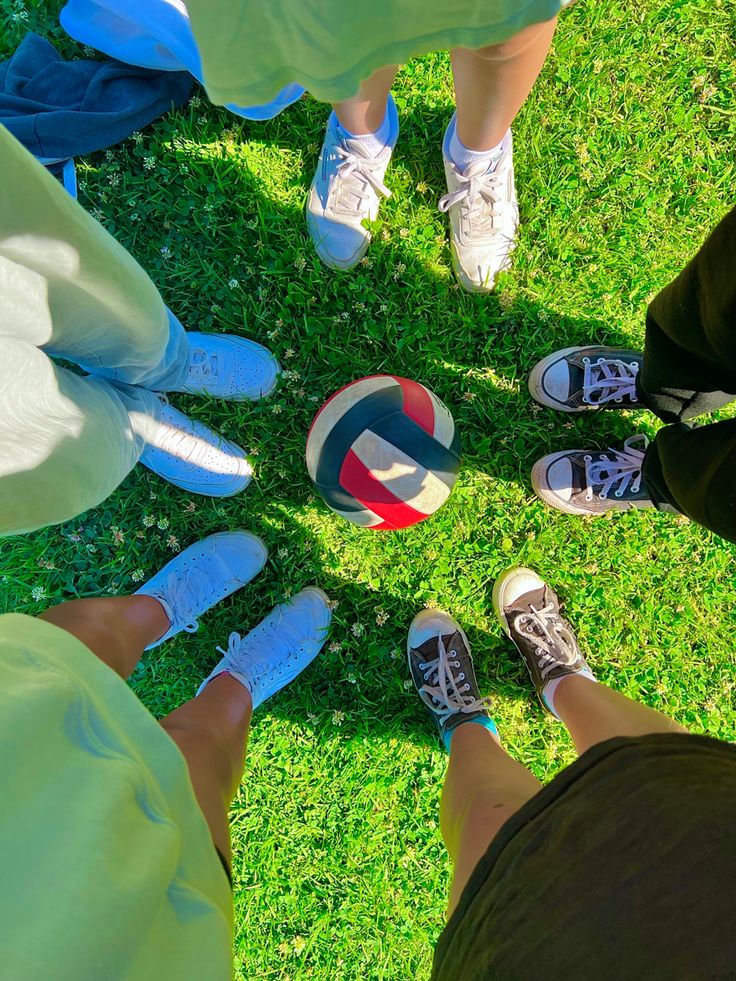 several people standing in a circle with their feet on top of each other and one holding a ball