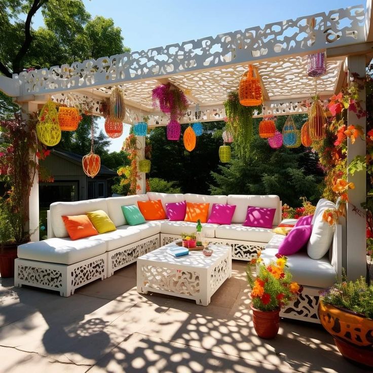 an outdoor living area with white couches and colorful decorations on the arborid wall