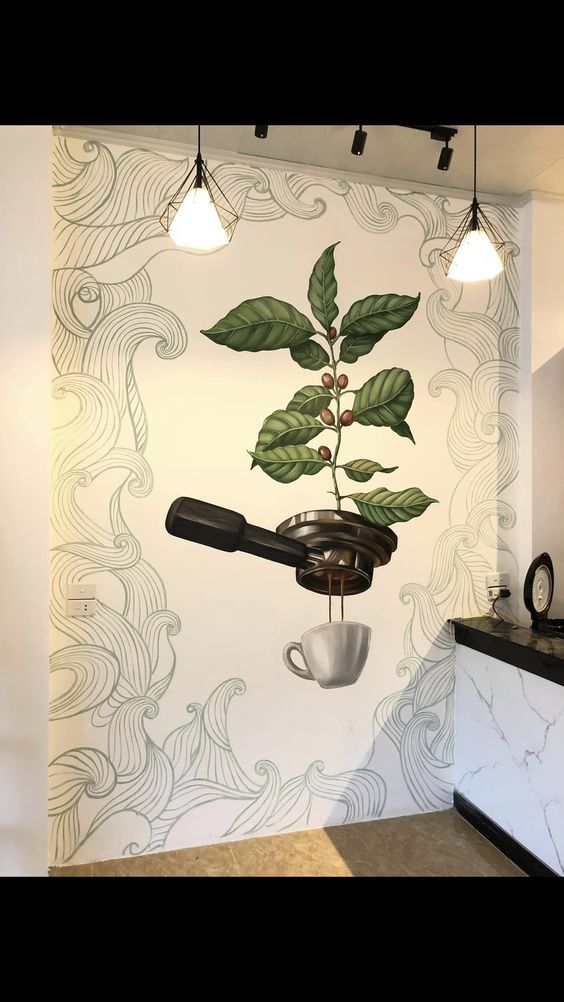 a coffee cup hanging from the side of a wall next to a plant with leaves on it