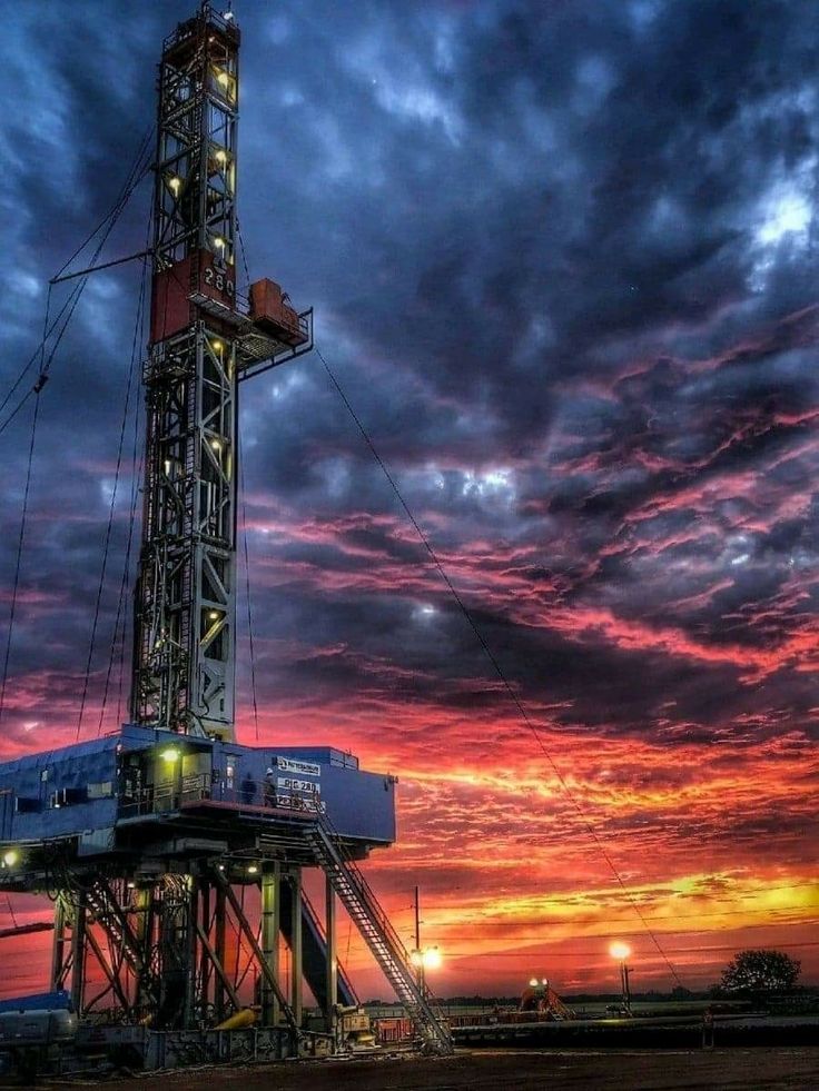 an oil rig at sunset with the sky in the background