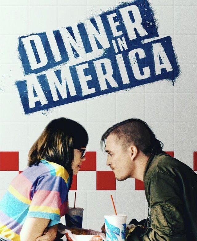 a man and woman sitting at a table in front of a sign that says dinner in america