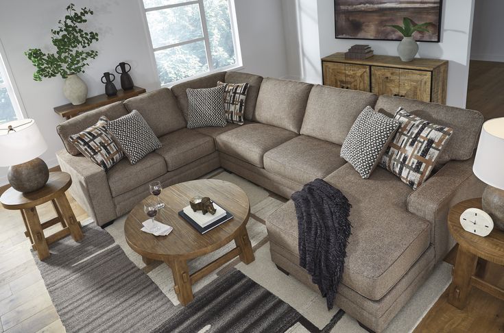 a living room with a sectional couch and coffee table in front of a large window