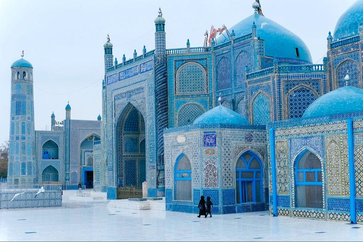 a person standing in front of some blue buildings