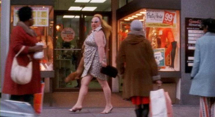 two women walking down the street in front of a store