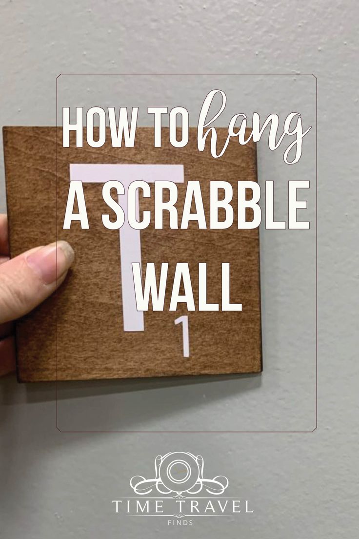 someone holding up a piece of cardboard with the words how to hang a scrabble wall on it