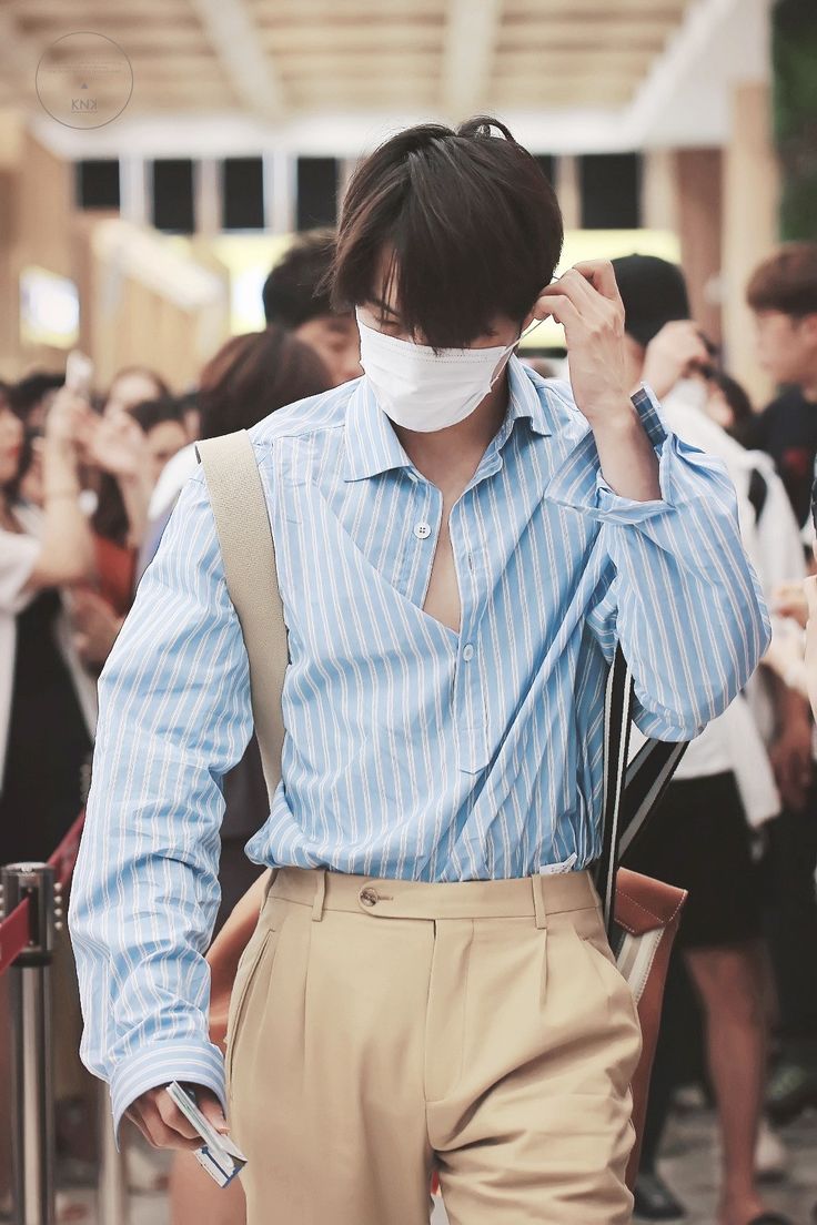 a man wearing a face mask while standing in front of a group of other people