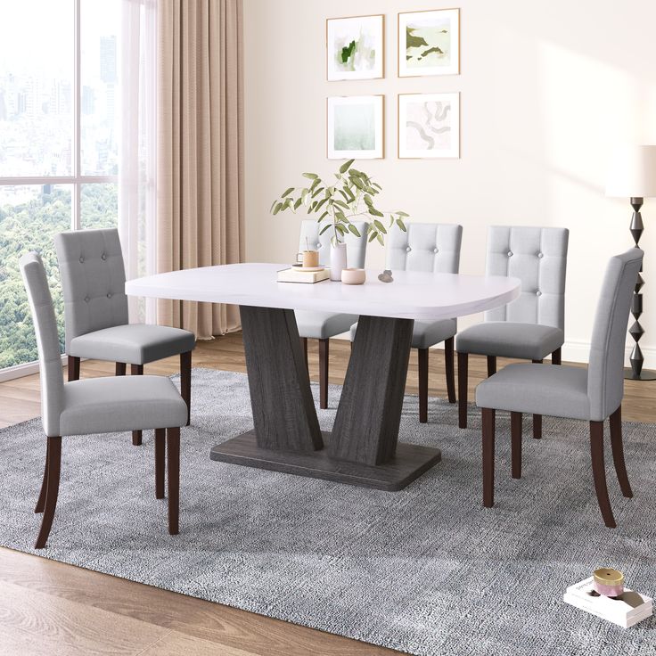 a dining room table and chairs with a rug on the floor in front of it