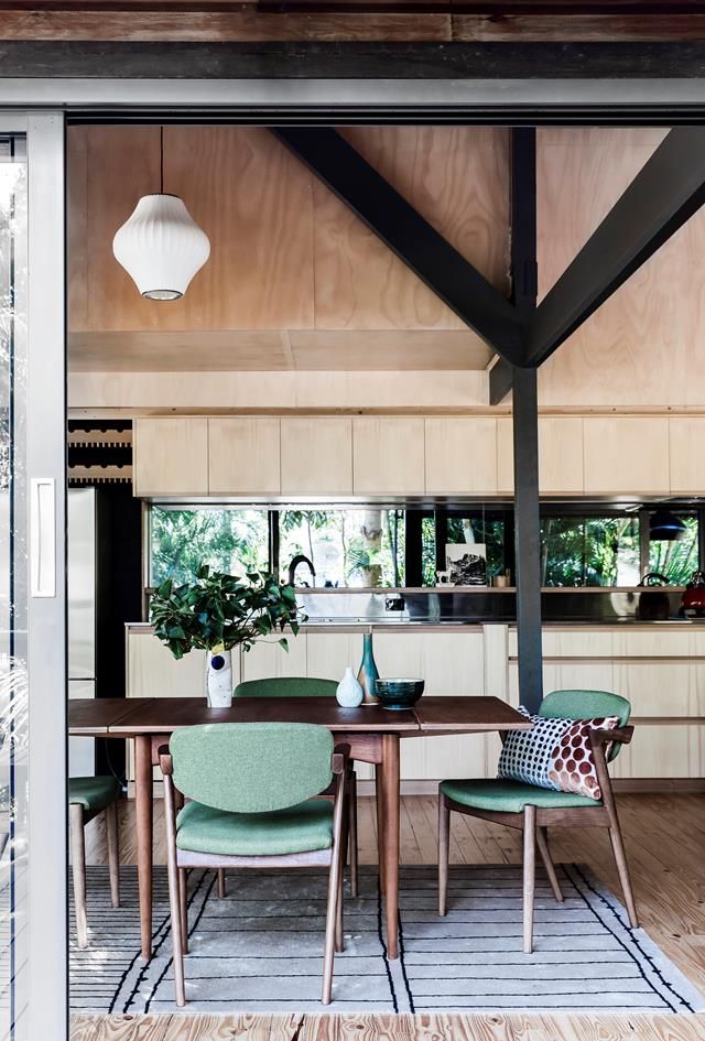 a table and chairs in a room with wooden flooring, white walls and ceiling