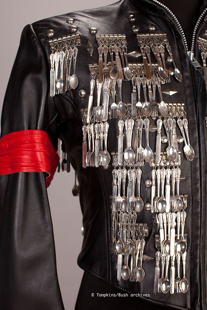 a black leather jacket with lots of silver forks and spoons on the back, attached to a red ribbon