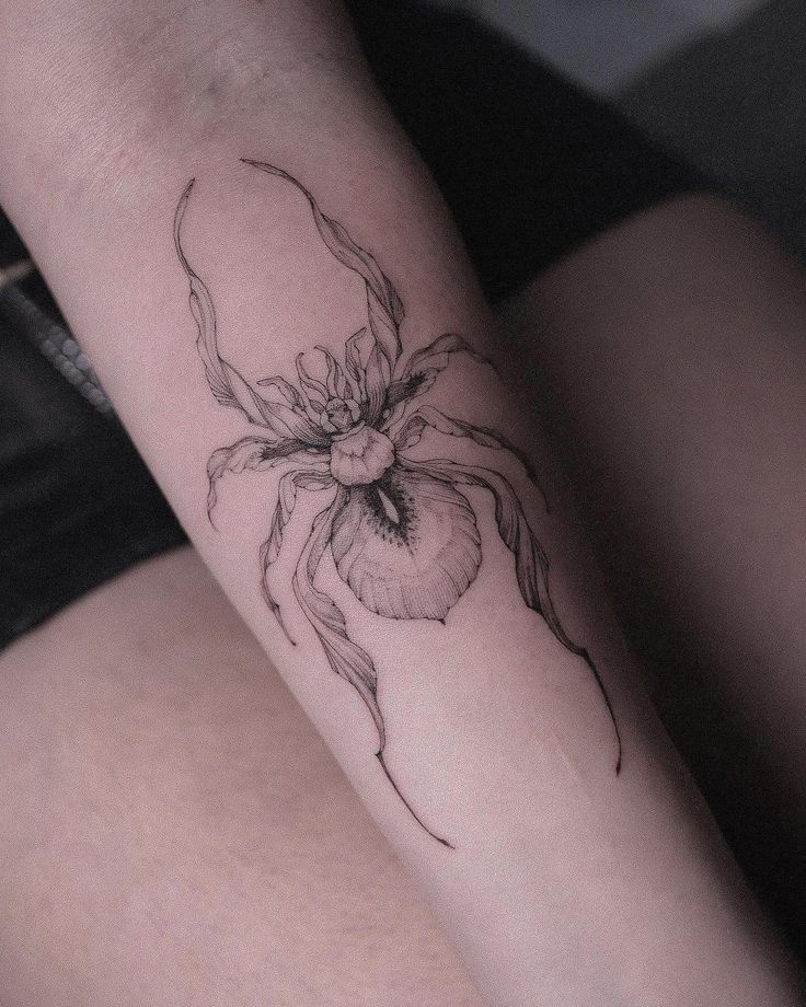 a woman's arm with a spider tattoo on the left side of her body