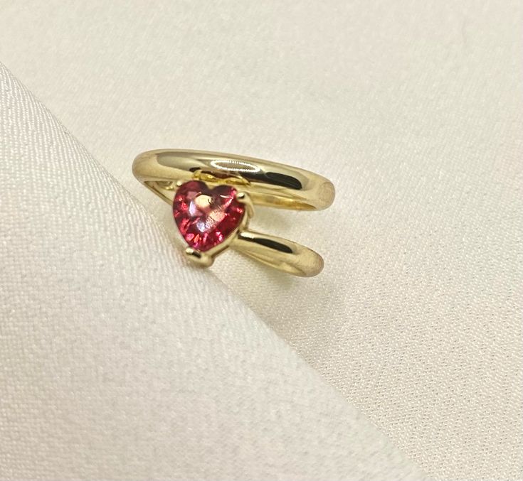 Our Heart Shaped Ruby Ring embodies a bright red ruby crystal as the main stone throughout its gold band ✔ Gold Plated 925 Sterling Silver ✔ Hypoallergenic ✔ Tarnish Free ✔ High Quality CARE: Our jewelry can handle a normal amount of contact with water and sweat, but we suggest limited contact for longer durability. We take pride in using high quality materials for those pieces that are not stainless steel or gold filled but we ask that you try to avoid contact with harsh chemicals that can mess Gold Heart Ring With Gemstone For Valentine's Day, Gold Gemstone Ring For Valentine's Day, Gold Ruby Ring For Valentine's Day, Valentine's Day Gold Ring With Gemstone, Valentine's Day Gold Rings With Gemstones, Valentine's Day Gold Gemstone Ring, Valentine's Day Gold Ruby Ring, Red Heart Birthstone Ring In 14k Gold, Red 14k Gold Heart Ring With Birthstone