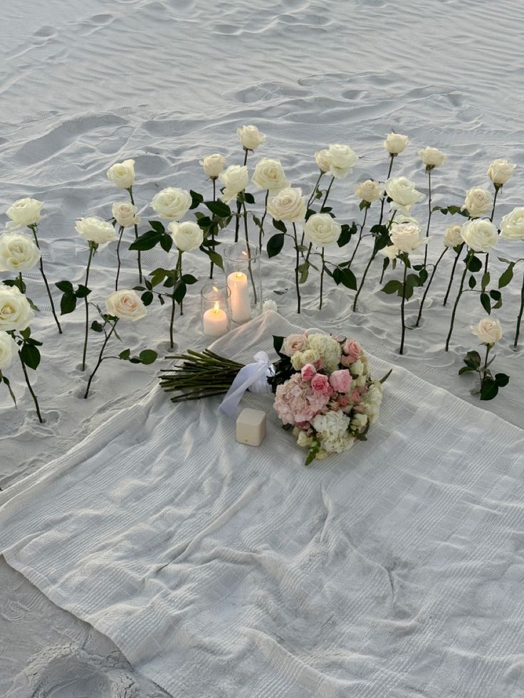 flowers and candles are laid out on the beach