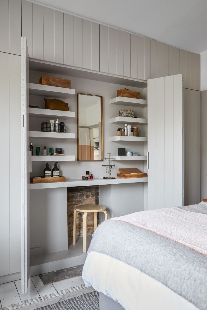 a bedroom with white walls and open shelving