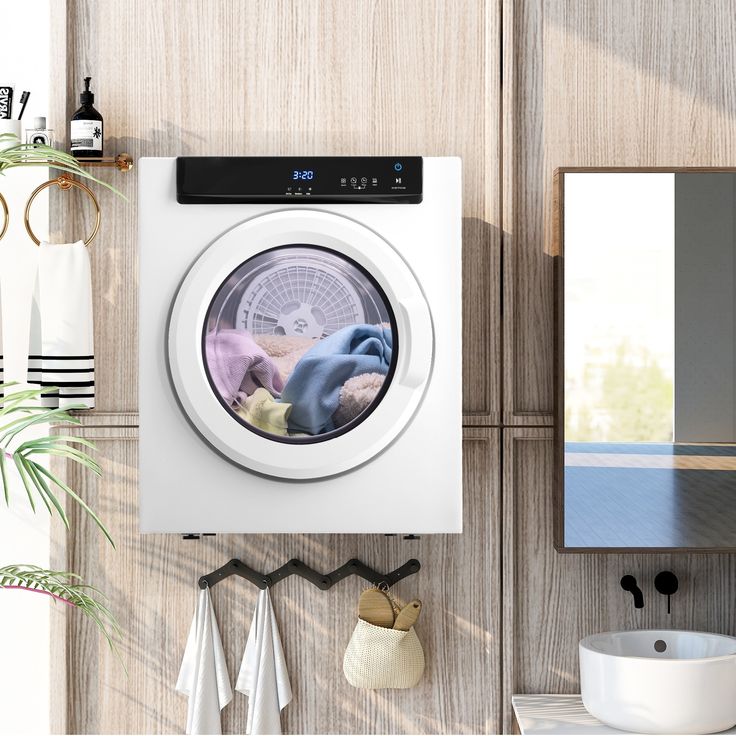 a washer and dryer in a bathroom next to a mirror with plants on it