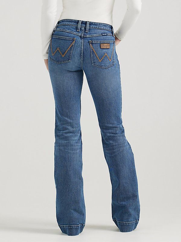 THE TROUSER: THE ULTIMATE IN WOMEN'S RETRO® JEANS Like all Wrangler Retro® jeans, our Mae wide-leg trouser jean is marked by its Western authenticity, making it a go-to style for cowgirls everywhere. With its contour waist and mid-rise fit, these women's trouser jeans are made to fit comfortably while they flatter all your curves. With more room at the knee and a gradual opening down the leg, the Mae wide-leg trouser gives you the room you need to stay active and in style. Wrangler Bootcut Jeans Women, Wrangler Flare Jeans, Women’s Wrangler Jeans, Wide Leg Jeans Western, Wrangler Jeans Aesthetic, Outfits To Wear With Boots, Country Wishlist, Horsemanship Patterns, Wrangler Jeans Womens