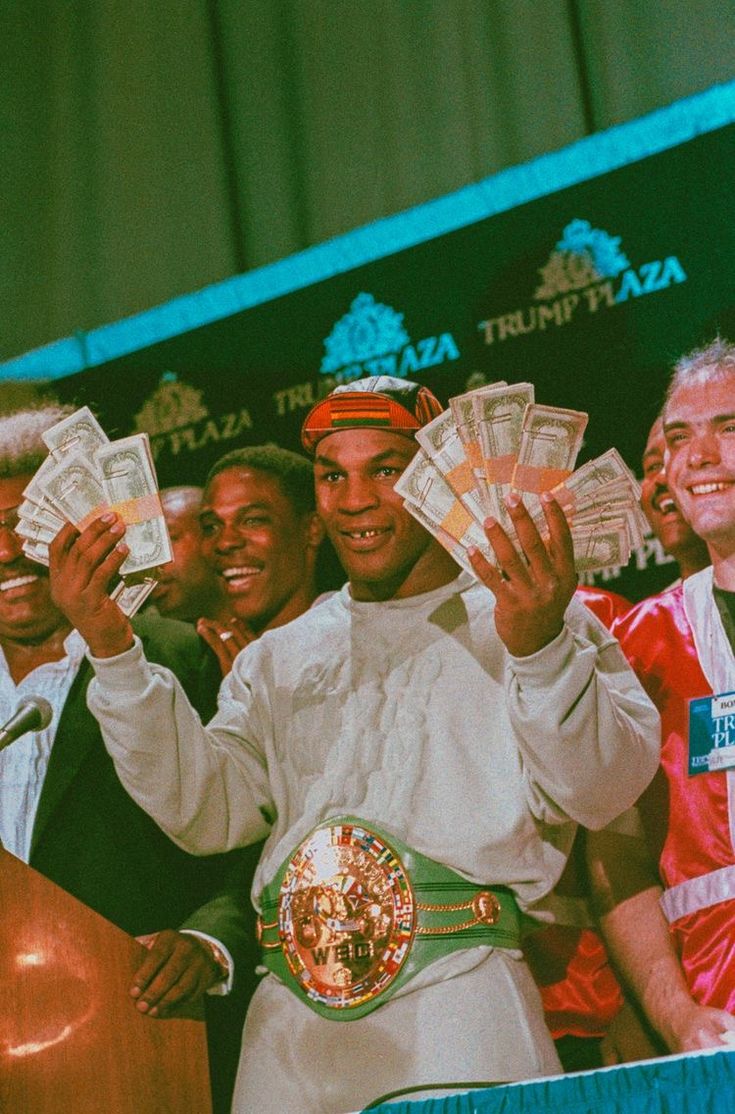 a group of men standing next to each other holding up money in front of them