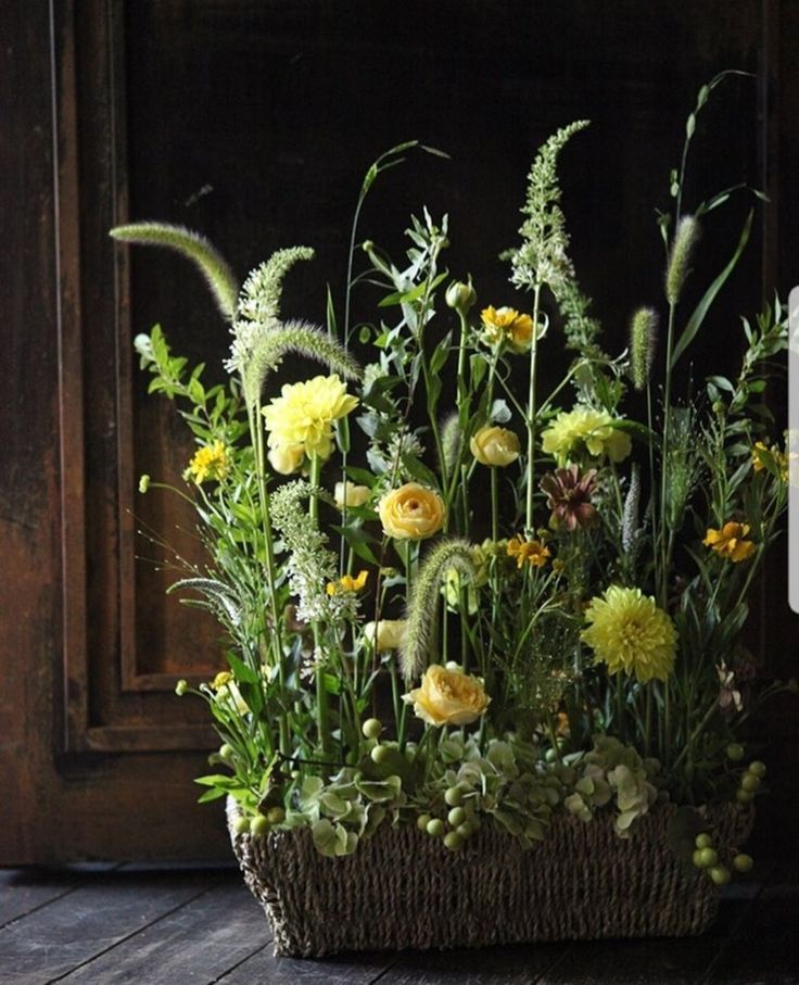 a basket filled with lots of flowers sitting on top of a wooden floor