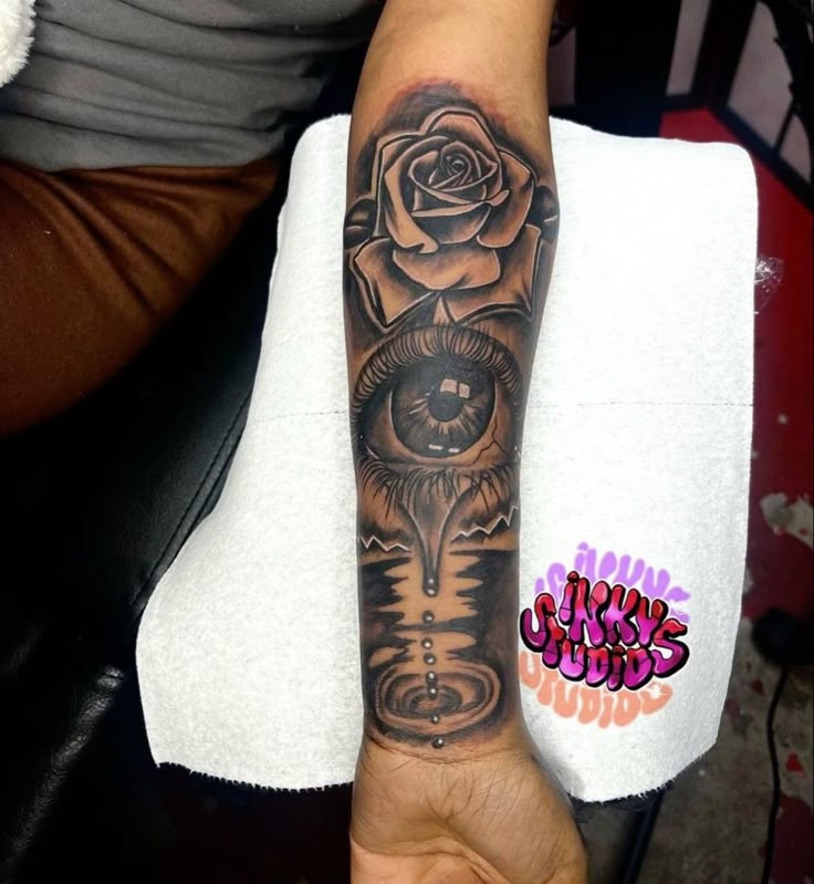 a person with a tattoo on their arm holding up a rose and an evil eye